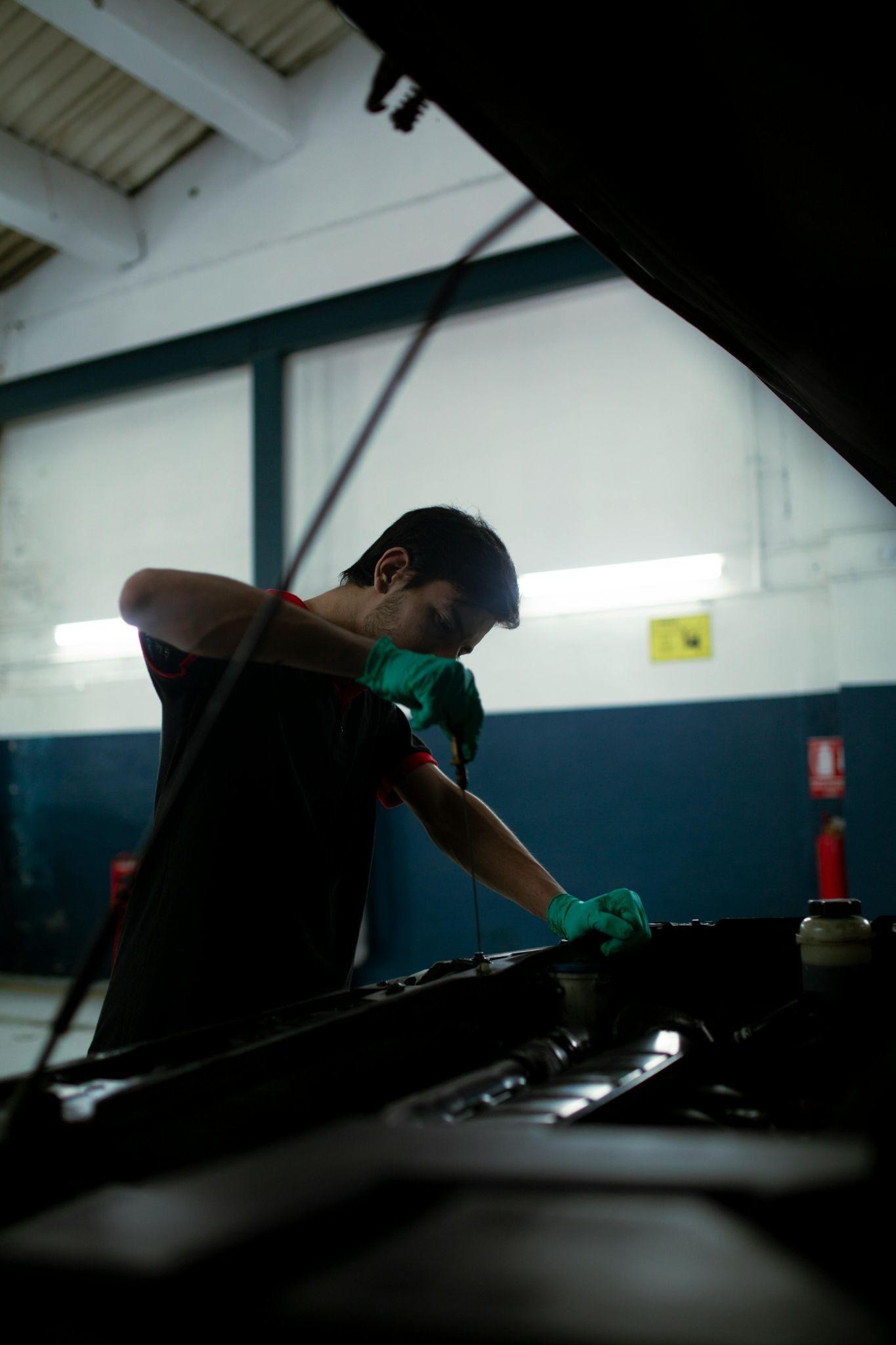 Mechanic checking for oil levels in a car